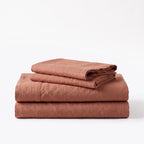 Folded stack of Rust European linen sheets